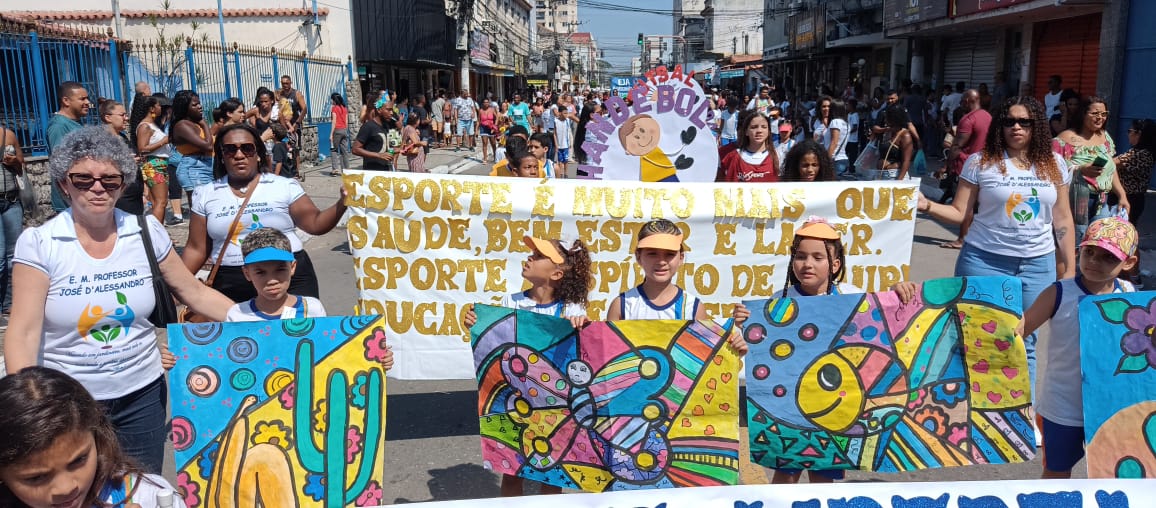 Desfile escolar comunitário com painéis de arte criados pelos alunos